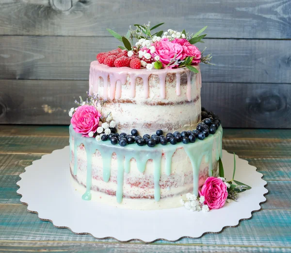 Wedding color drip cake with roses, blueberries and  raspberries