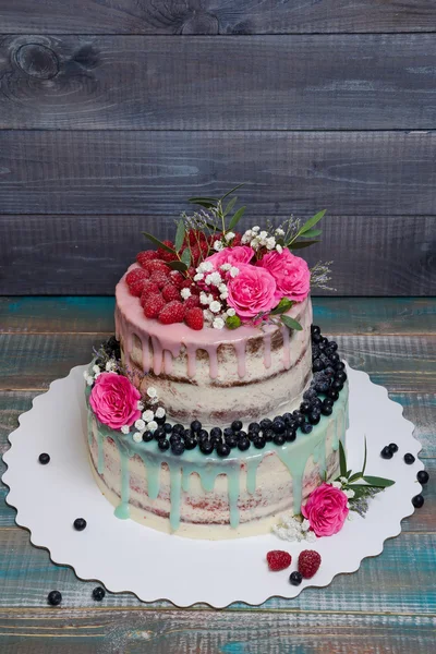 Wedding color drip cake with roses, blueberries and  raspberries