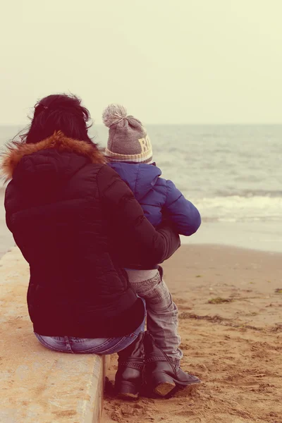 Mother and son watching the sea in winter