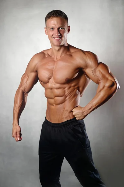 Strong athletic man fitness model showing medal