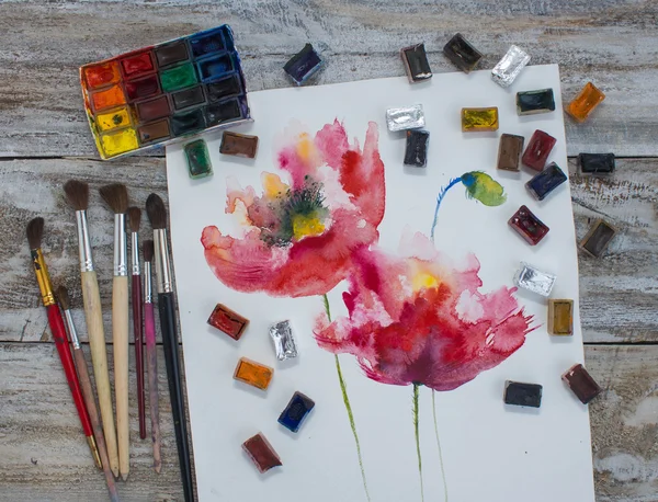 Watercolor paint, brush, painted flowers.