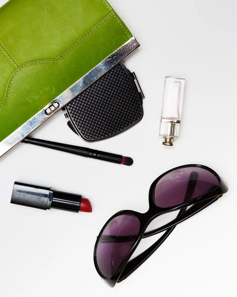 Top view accessories for woman. Stylish sunglasses, green bag , lipstick , perfume , fashion   flat lay on white