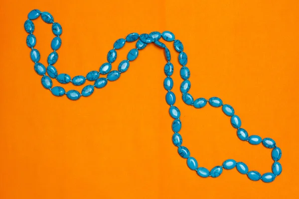 Beads with natural stone turquoise closeup on orange background