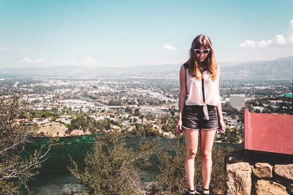 Girl at Hollywood Hills with panoramic view of Los Angeles