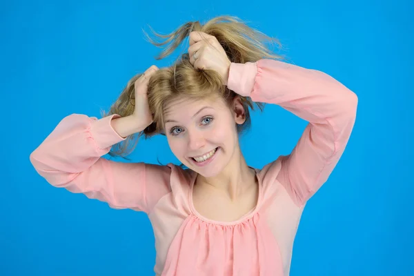 A silly smile blonde girl holding his hair