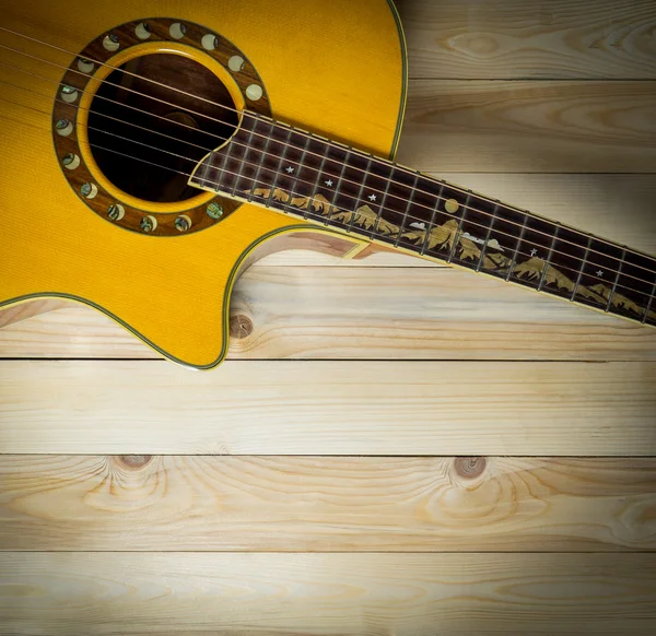 Acoustic guitar on wooden panel with copy space vignetting