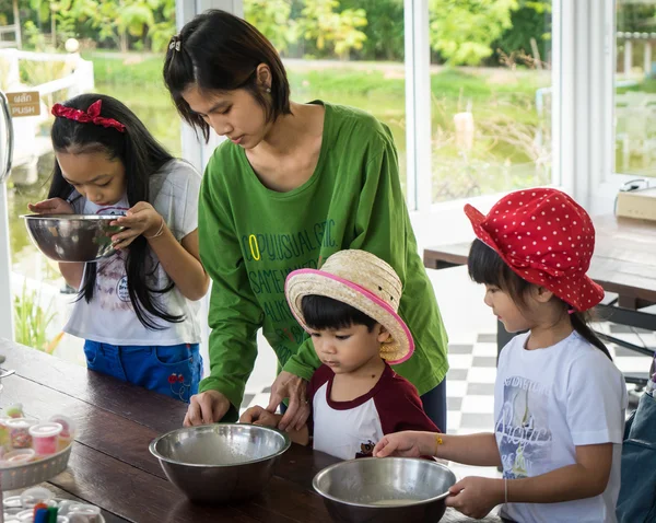Family with small children are cooking in a Bakery cooking class.
