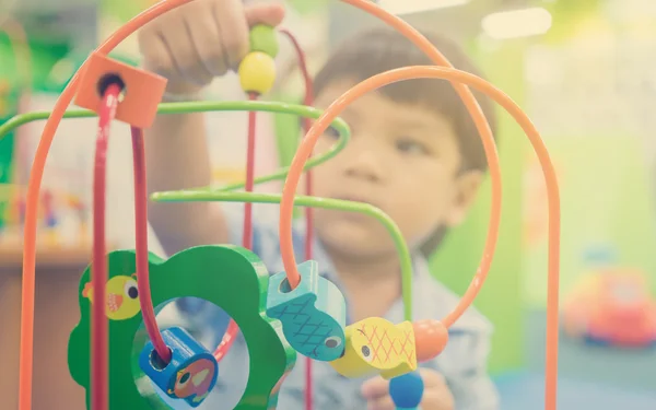 Asian children playing on educational toy. Japanese baby learning to count with colorful toy. Number learning practice in kindergarten class room for children.