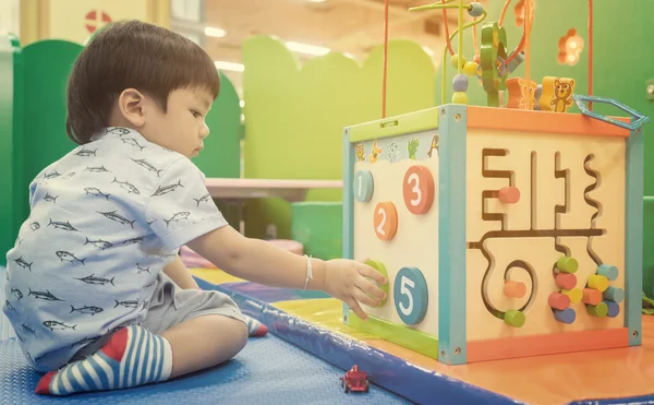 Asian children playing on educational toy. Japanese baby learning to count with colorful toy. Number learning practice in kindergarten class room for children.