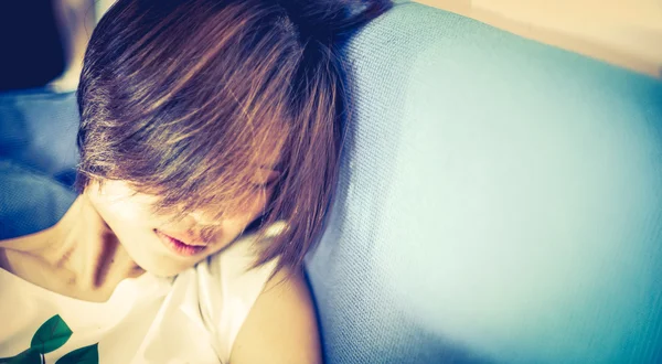 Short Hair Japanese Teenager sleeping on sofa. With copy space. Vintage Sepia color tone.