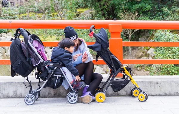 A mother is showing her son the map while traveling on Miyajima Island.