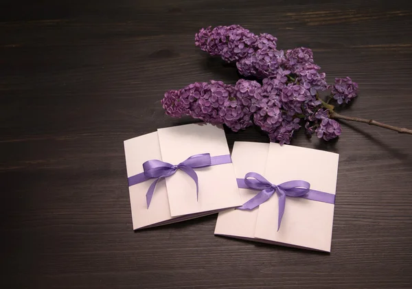 Composition with handmade cards and branch of lilac blossoms