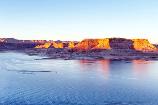 Two boats floating on the lake Powell between the rocks of the canyon