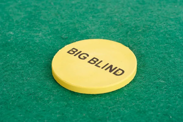 Big blind chip on green cloth background