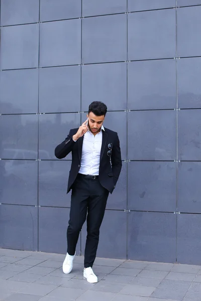 Handsome arabic man talks on smart phone in business center