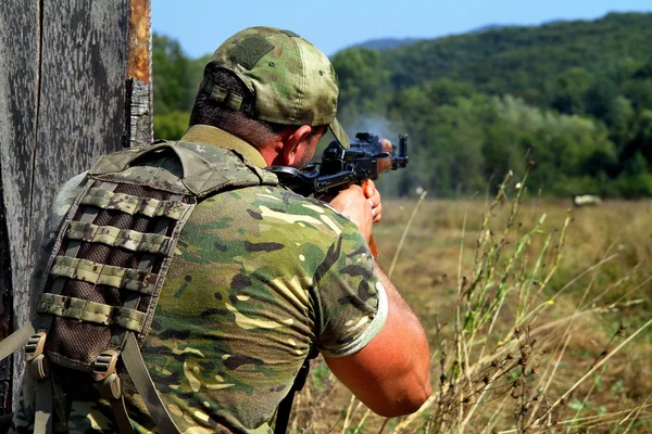 Soldier shooting with Kalashnikov assault rifle