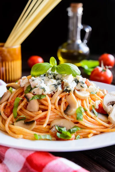 Spaghetti pasta salad with tomato sauce, mushrooms, blue cheese and basil