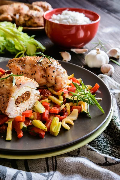 Baked chicken breast stuffed with cheese, tomato and basil with rice and steamed vegetable salad