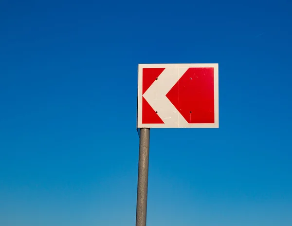 Small red traffic sign against a blue sky