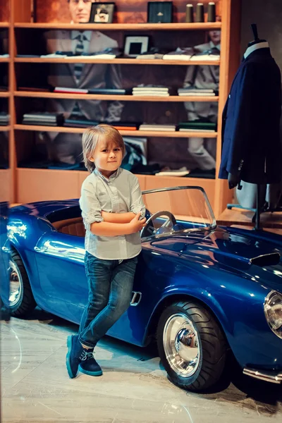 Little boy by toy vintage car