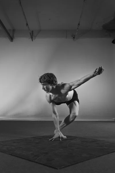Young stong man dancing in the studio. Flexible body.Black and white.