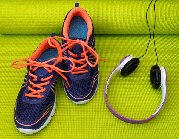 Bright Shoes and Headphones on Rolled Yoga Mat