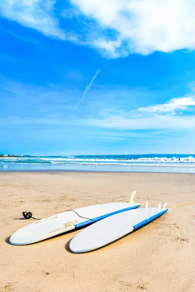 Surfboards laying down on the sand at the beach.