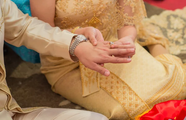 The bride wore a bride groom\'s wedding ring in traditional wedding ceremony Thailand