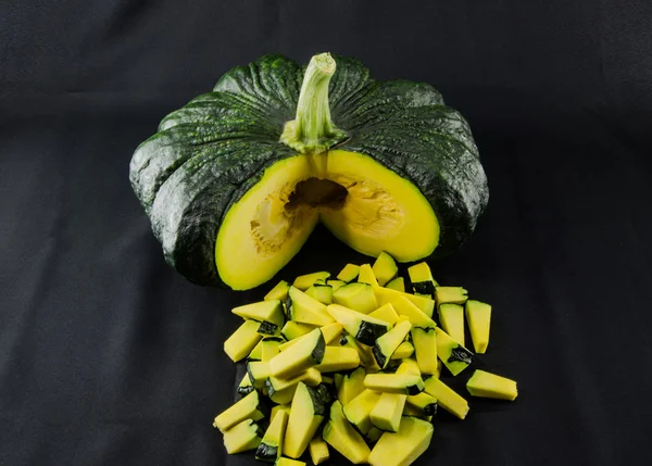 Sliced raw yellow pumpkin on black background. Sliced yellow pum