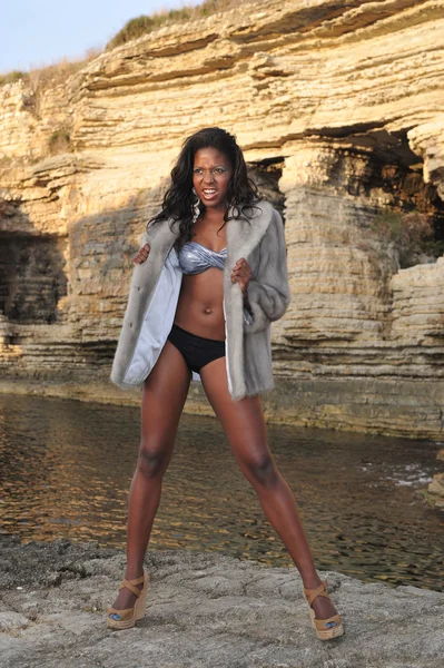 Beautiful young African black model posing on the rocks