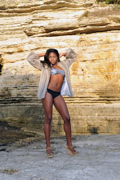 Beautiful young African black model posing on the rocks