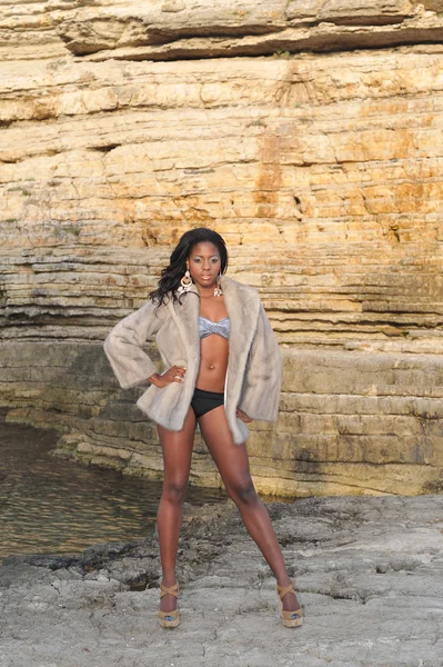 Beautiful young black model posing on the rocks