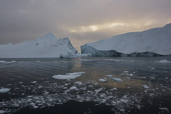 Arctic Icebergs Greenland in the arctic sea. You can easily see that iceberg is over the water surface, and below the water surface. Sometimes unbelievable that 90% of an iceberg is under water