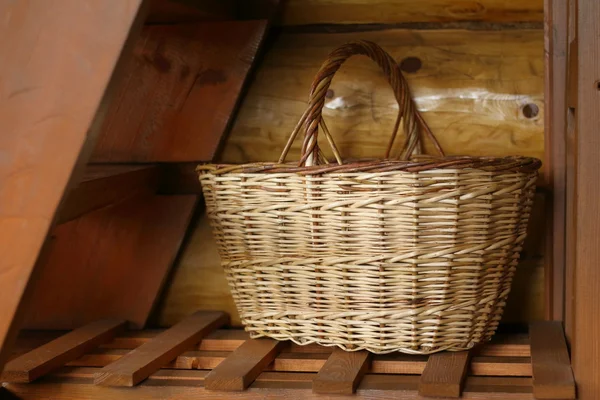 Wicker basket under the stairs.