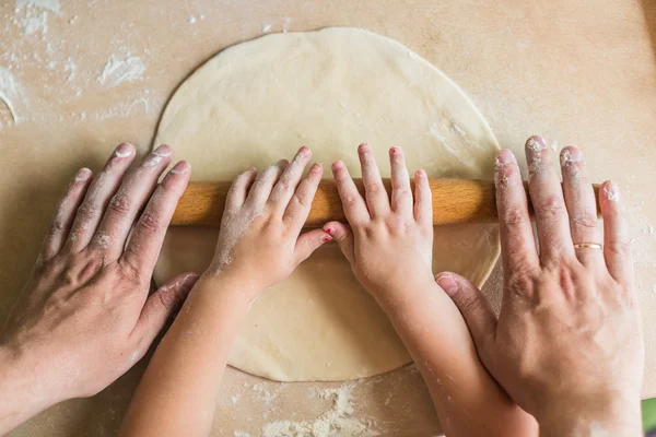 Children and dad hands rolled dough