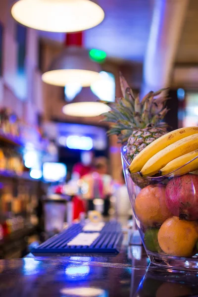 Bar at Night. Blurred Back Bar. Bowl of Fruit on Bar Counter.