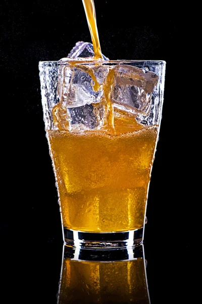 Pooring soft drink in a glass with ice