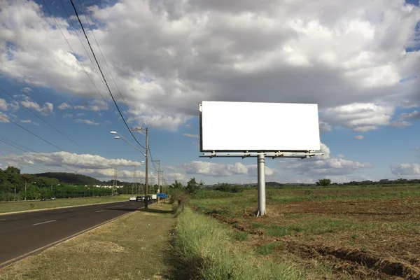 Empty billboard in front of beautiful cloudy sky in a rural location