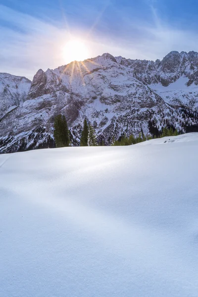 Winter sun over snowy mountain peaks