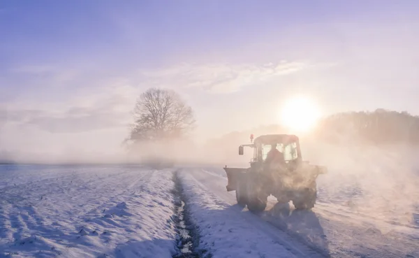 Tractor silhouette on snowy field