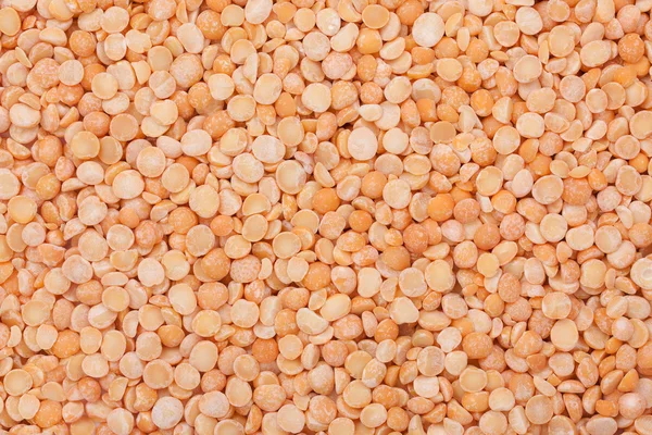 Background with dried yellow peas close-up, top view.