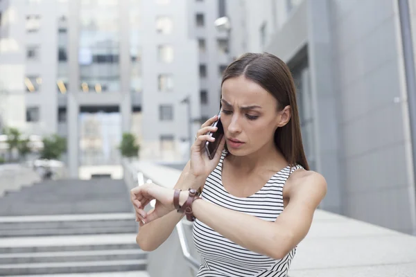 Business woman being late talking on the phone.