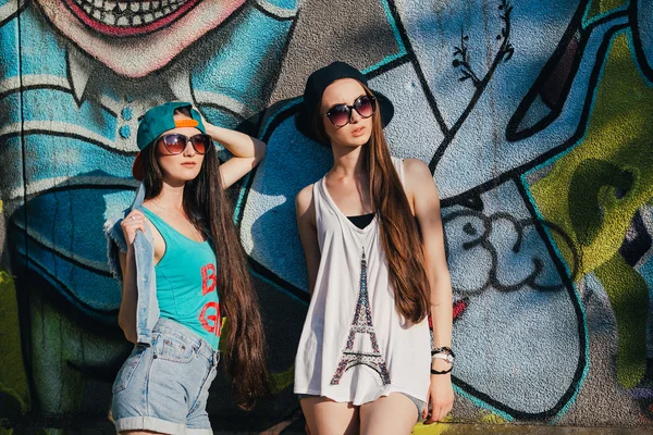 Young girls near graffiti wall