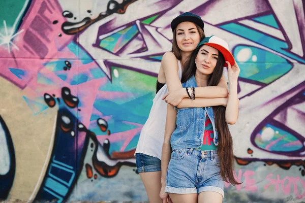 Young girls near graffiti wall