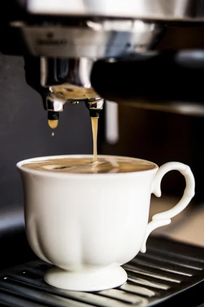 Espresso machine making coffee and pouring in a white  cup