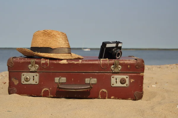 Suitcase old and a hat with the camera