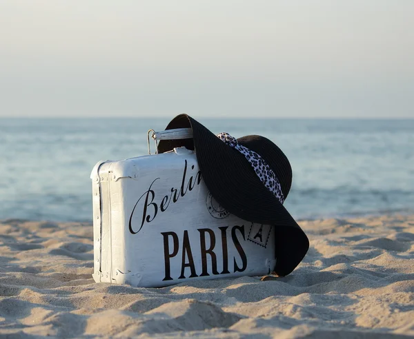 Suitcase old white and a black hat