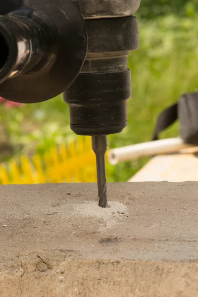 Hammer drills concrete on a green background