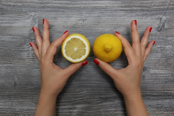 Half a lemon in the left hand and whole lemon in the right hand