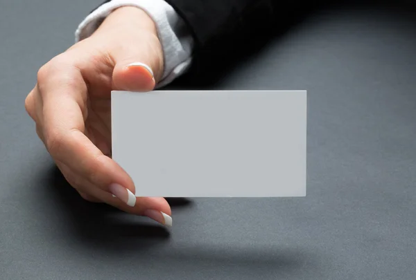 Youung office woman is holding blank white card